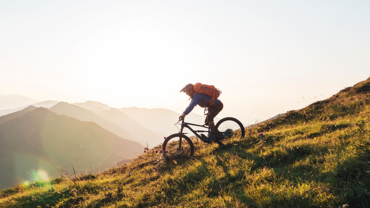 Mann fährt mit Mountainbike den Berg hinunter